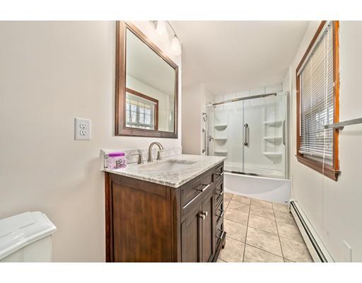 107 Oak Street Middleboro, MA 02346 - Photo 13 of 24 a bathroom with a granite countertop sink a toilet a mirror and shower