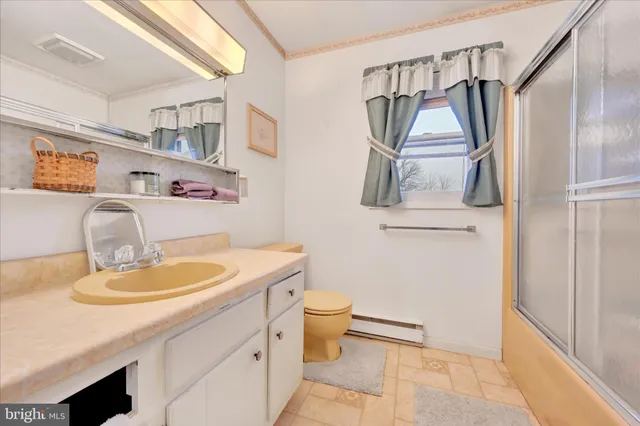 a bathroom with a granite countertop sink a toilet and a mirror