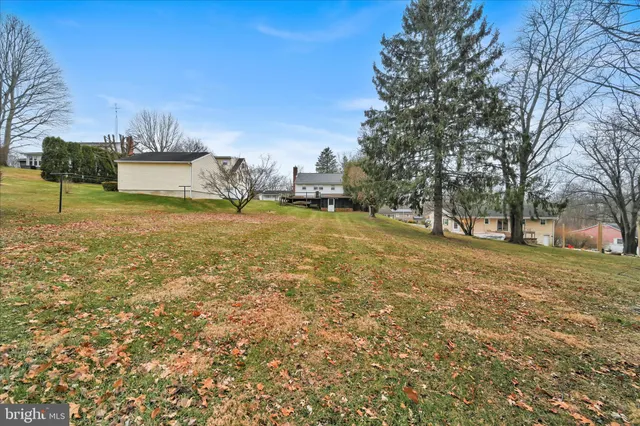 a view of a white house with a swimming pool and sitting area