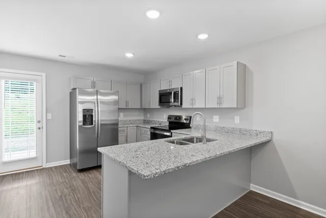 a kitchen with stainless steel appliances granite countertop a sink refrigerator and microwave