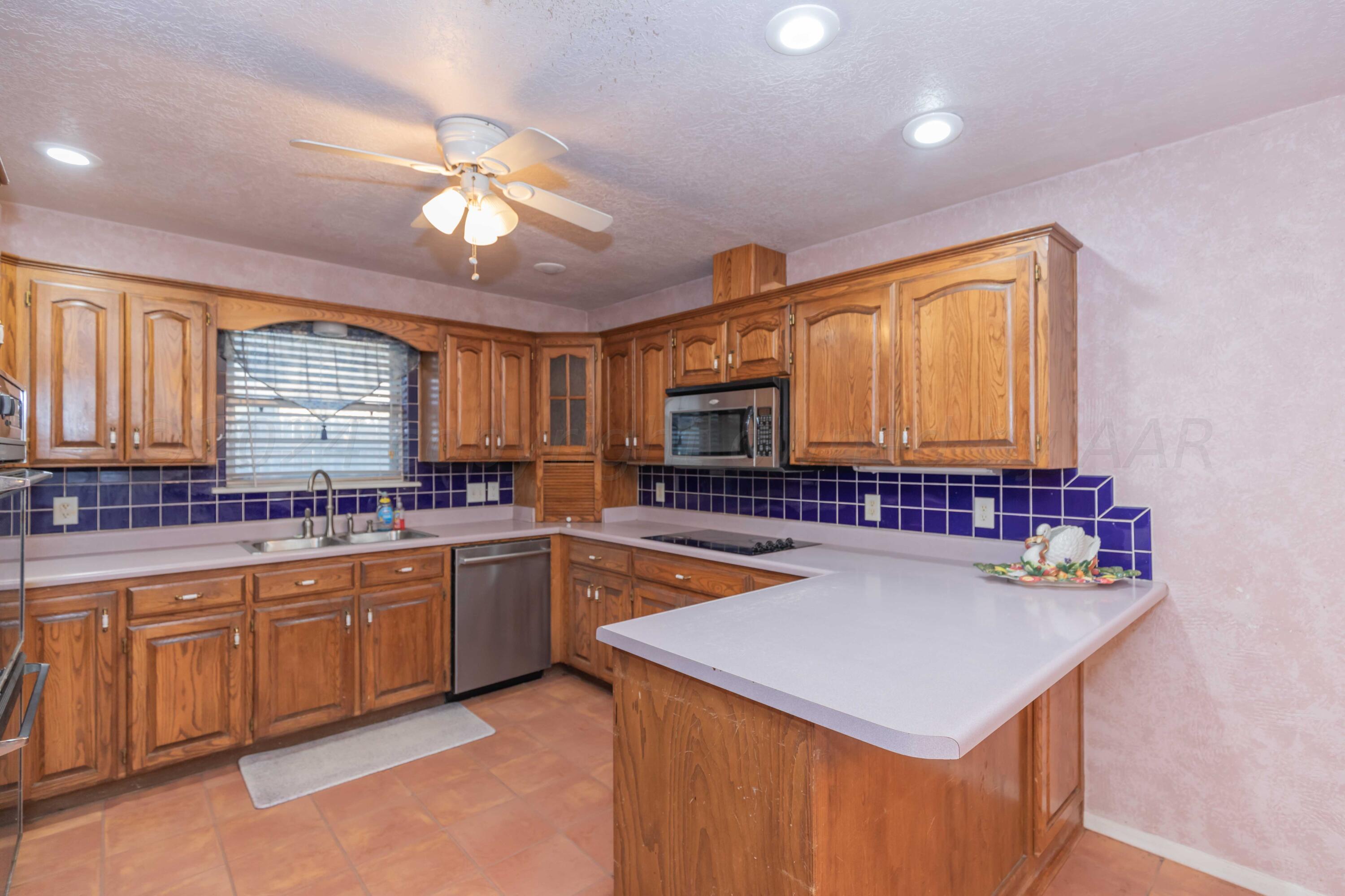 4721 Shawnee Trail Amarillo, TX 79109 - Photo 26 of 52 a kitchen with a stove a sink and a refrigerator