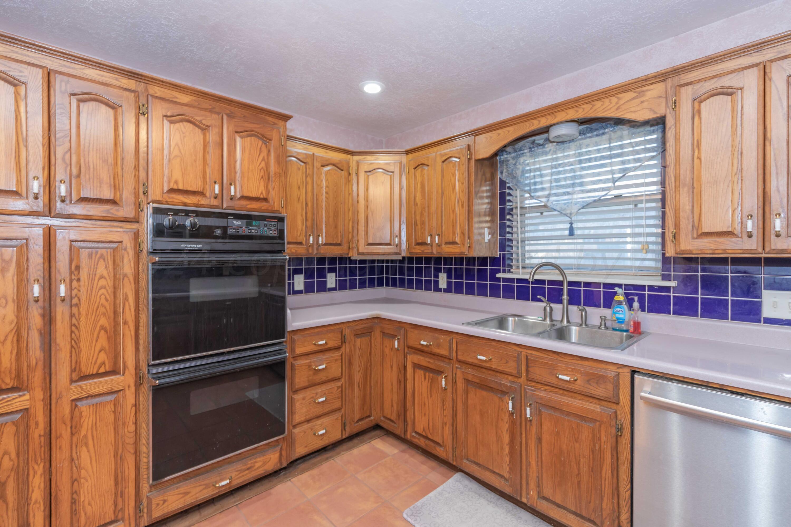 4721 Shawnee Trail Amarillo, TX 79109 - Photo 27 of 52 a kitchen with stainless steel appliances granite countertop a refrigerator and a sink