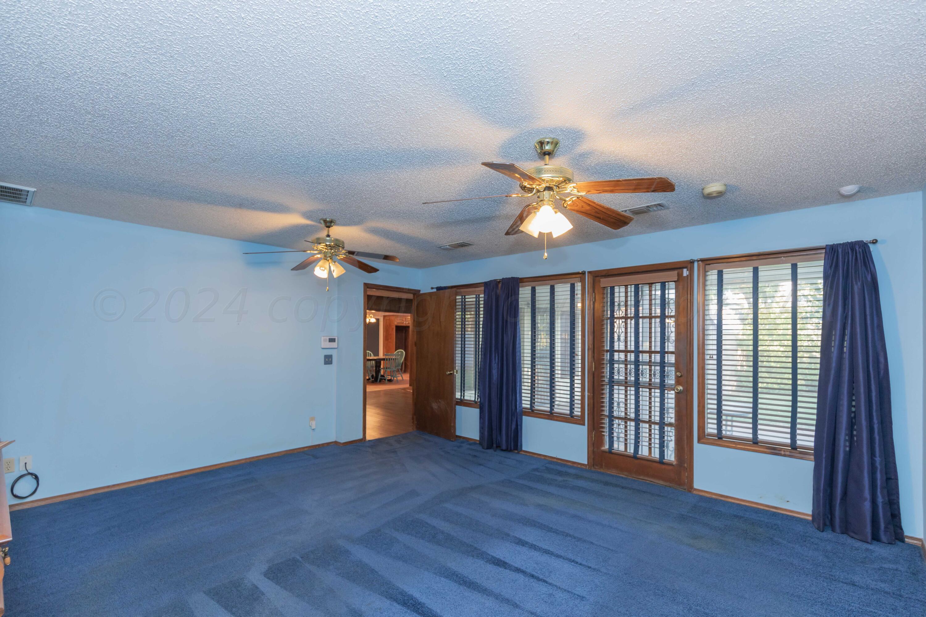 4721 Shawnee Trail Amarillo, TX 79109 - Photo 33 of 52 a view of an empty room with wooden floor and a ceiling fan