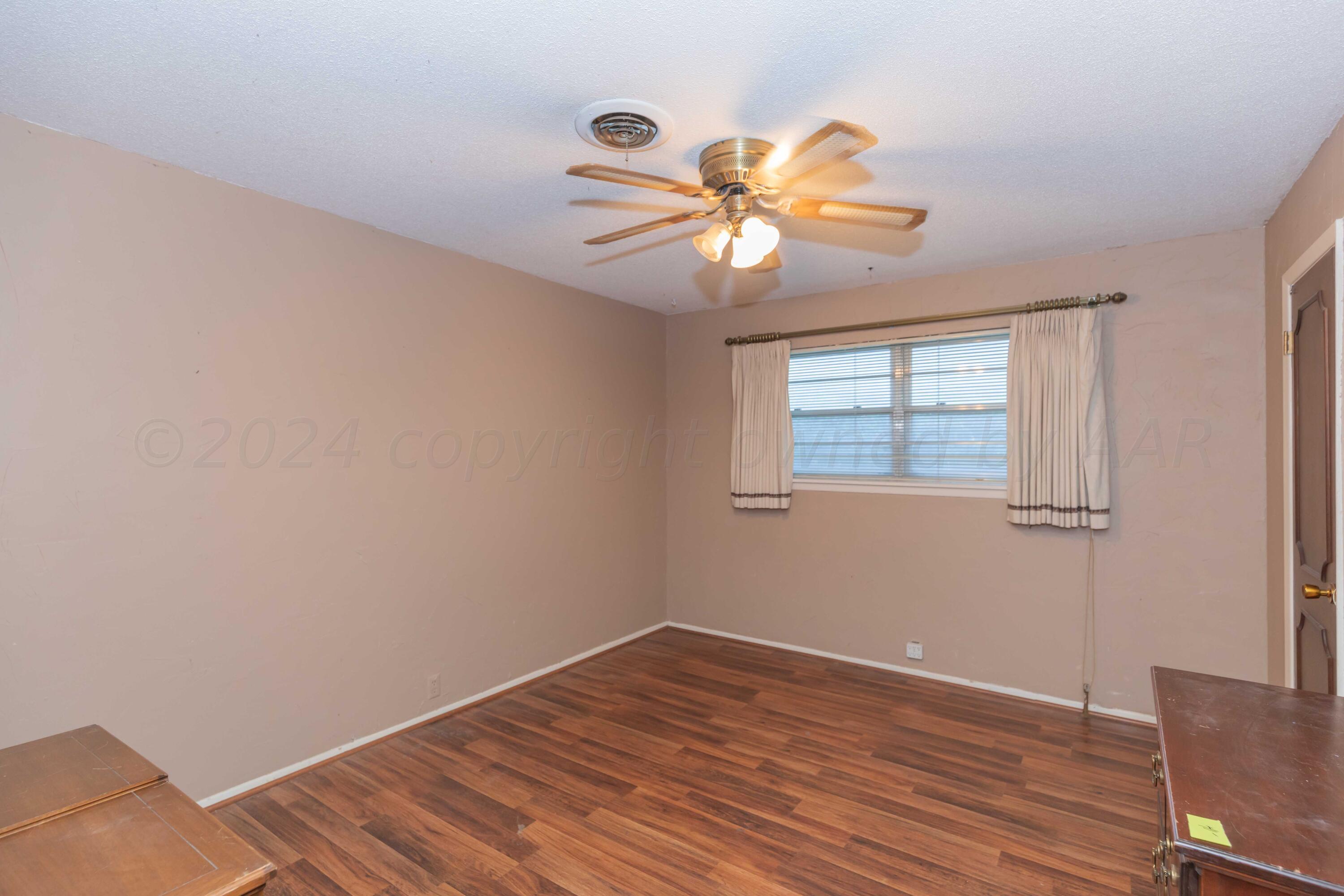 4721 Shawnee Trail Amarillo, TX 79109 - Photo 41 of 52 a view of an empty room with wooden floor and a window