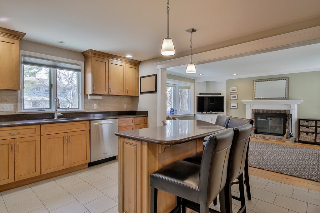a kitchen with stainless steel appliances granite countertop a stove a sink a microwave a dining table and chairs