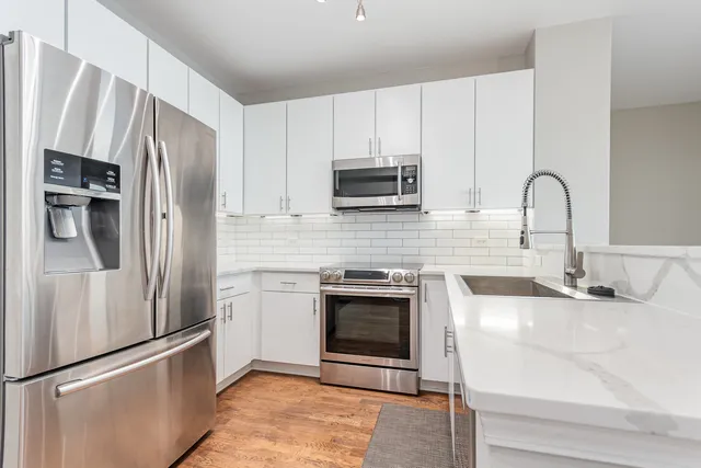 a kitchen with stainless steel appliances granite countertop a refrigerator sink and microwave