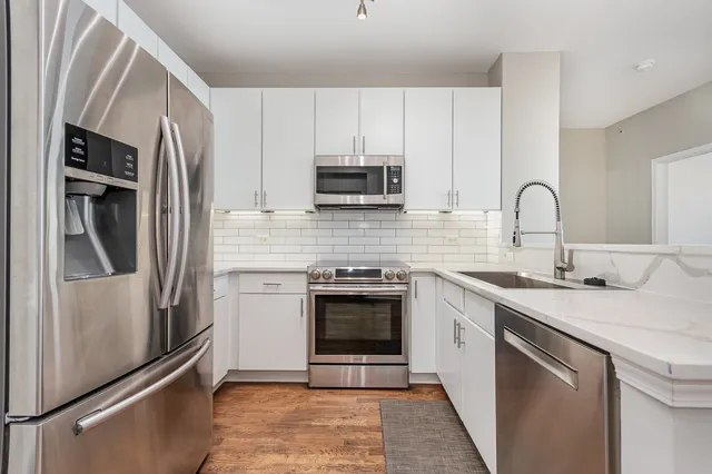a kitchen with stainless steel appliances granite countertop a refrigerator sink and stove