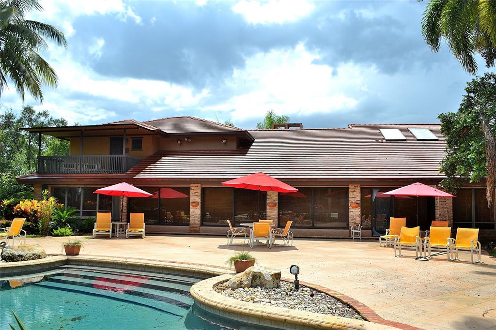 6200 Southwest 183rd Way Southwest Ranches, FL 33331 - Photo 12 of 18 a patio with a table and chairs under an umbrella