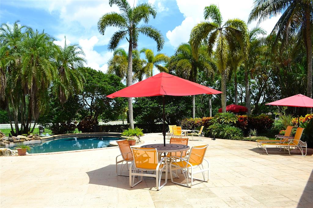 6200 Southwest 183rd Way Southwest Ranches, FL 33331 - Photo 13 of 18 a patio with a table and chairs under an umbrella