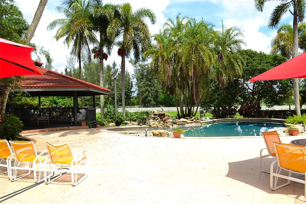 6200 Southwest 183rd Way Southwest Ranches, FL 33331 - Photo 2 of 18 a view of swimming pool with table and chairs under an umbrella