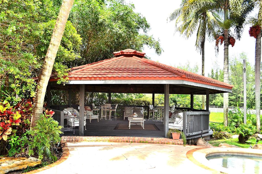 6200 Southwest 183rd Way Southwest Ranches, FL 33331 - Photo 4 of 18 a view of a patio with a table and chairs under an umbrella