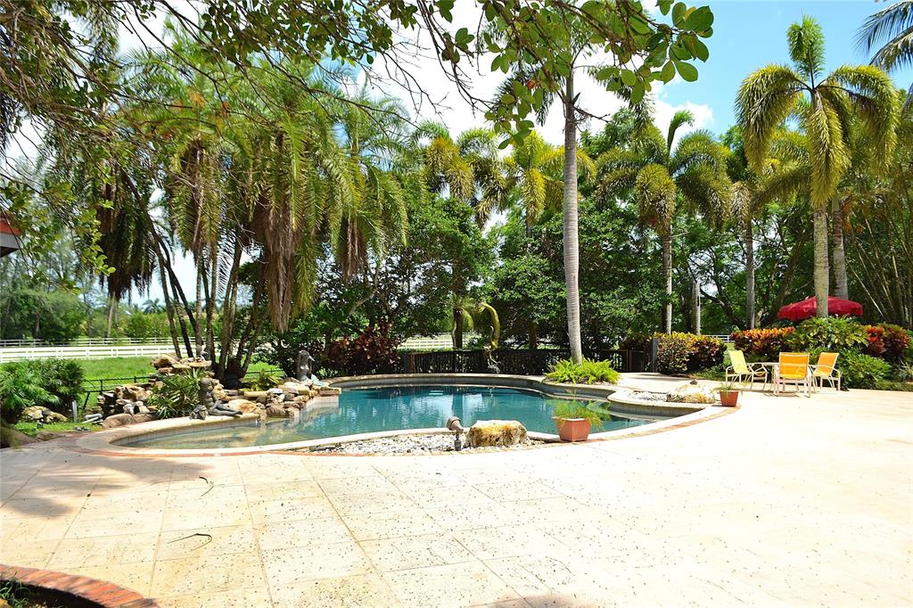 6200 Southwest 183rd Way Southwest Ranches, FL 33331 - Photo 10 of 18 a view of a swimming pool and a bench in the patio next to a yard