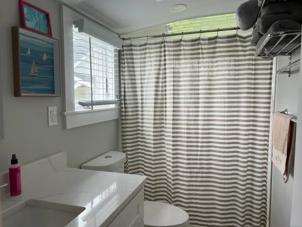 a bathroom with a sink a toilet and shower curtain