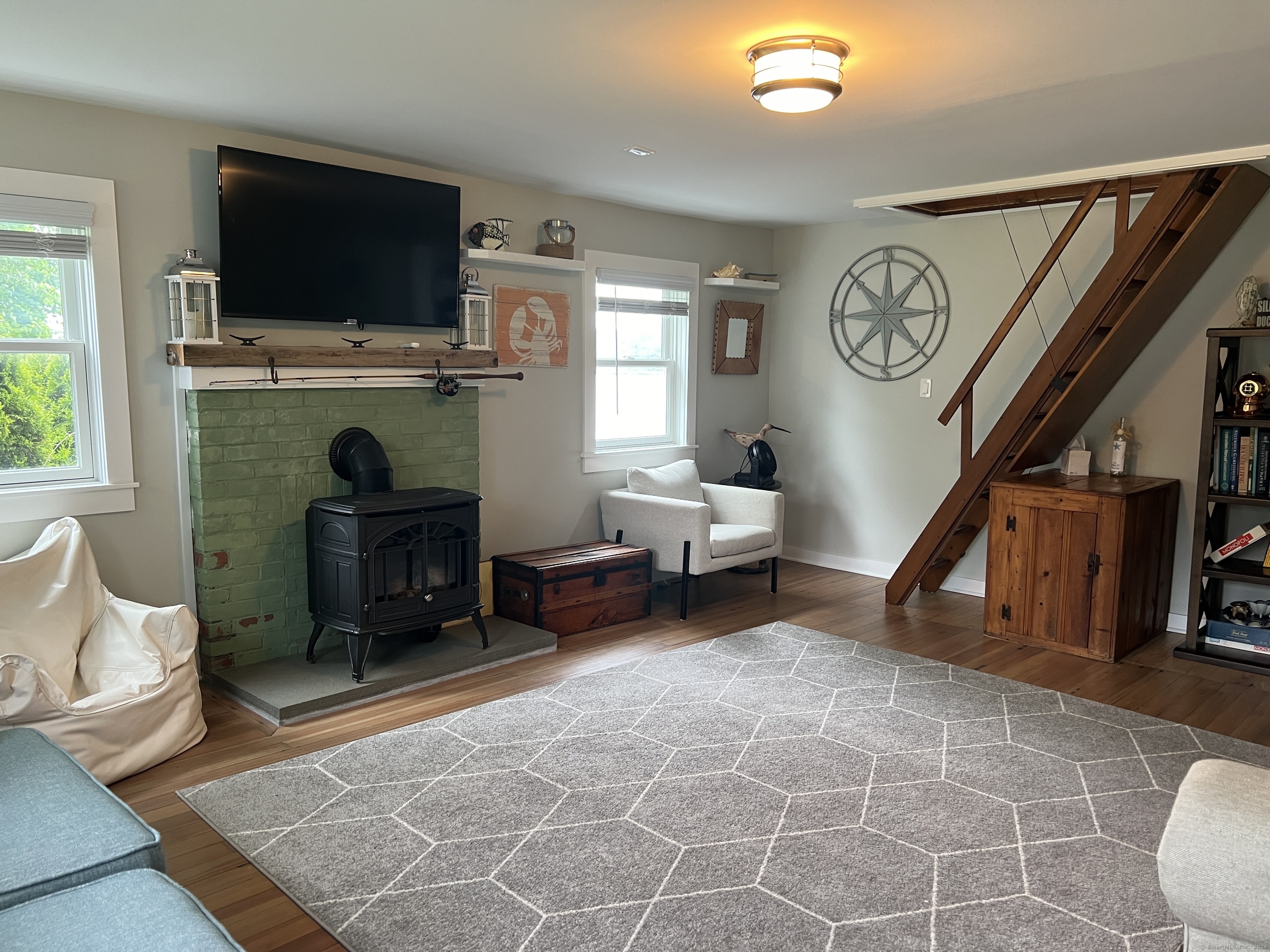 61 Old Black Point Road East Lyme, CT 06357 - Photo 16 of 27 a living room with furniture a flat screen tv and a fireplace
