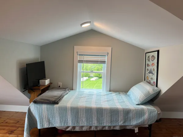 a bedroom with a bed and a television