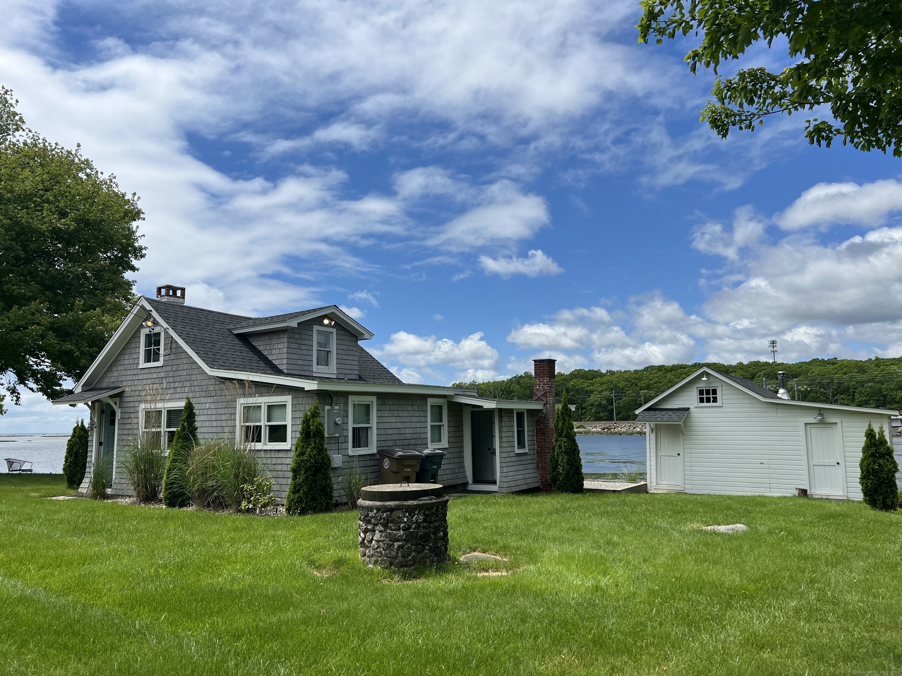 61 Old Black Point Road East Lyme, CT 06357 - Photo 3 of 27 a front view of a house with a garden and yard