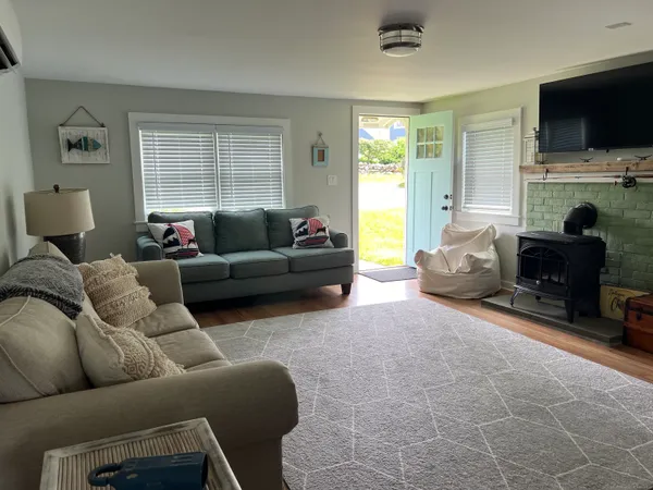 a living room with furniture a flat screen tv and a window