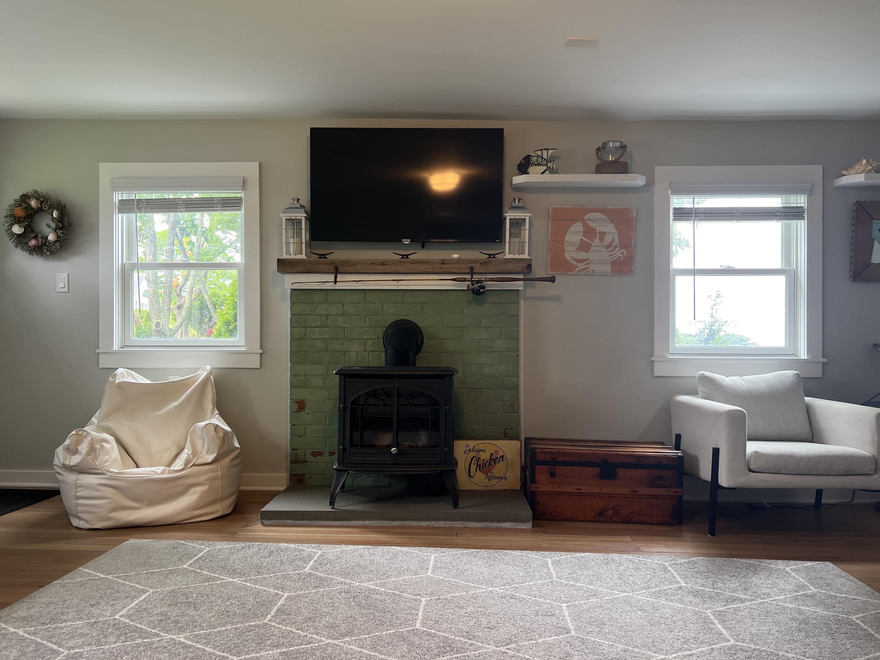 61 Old Black Point Road East Lyme, CT 06357 - Photo 5 of 27 a living room with furniture a flat screen tv and a fireplace