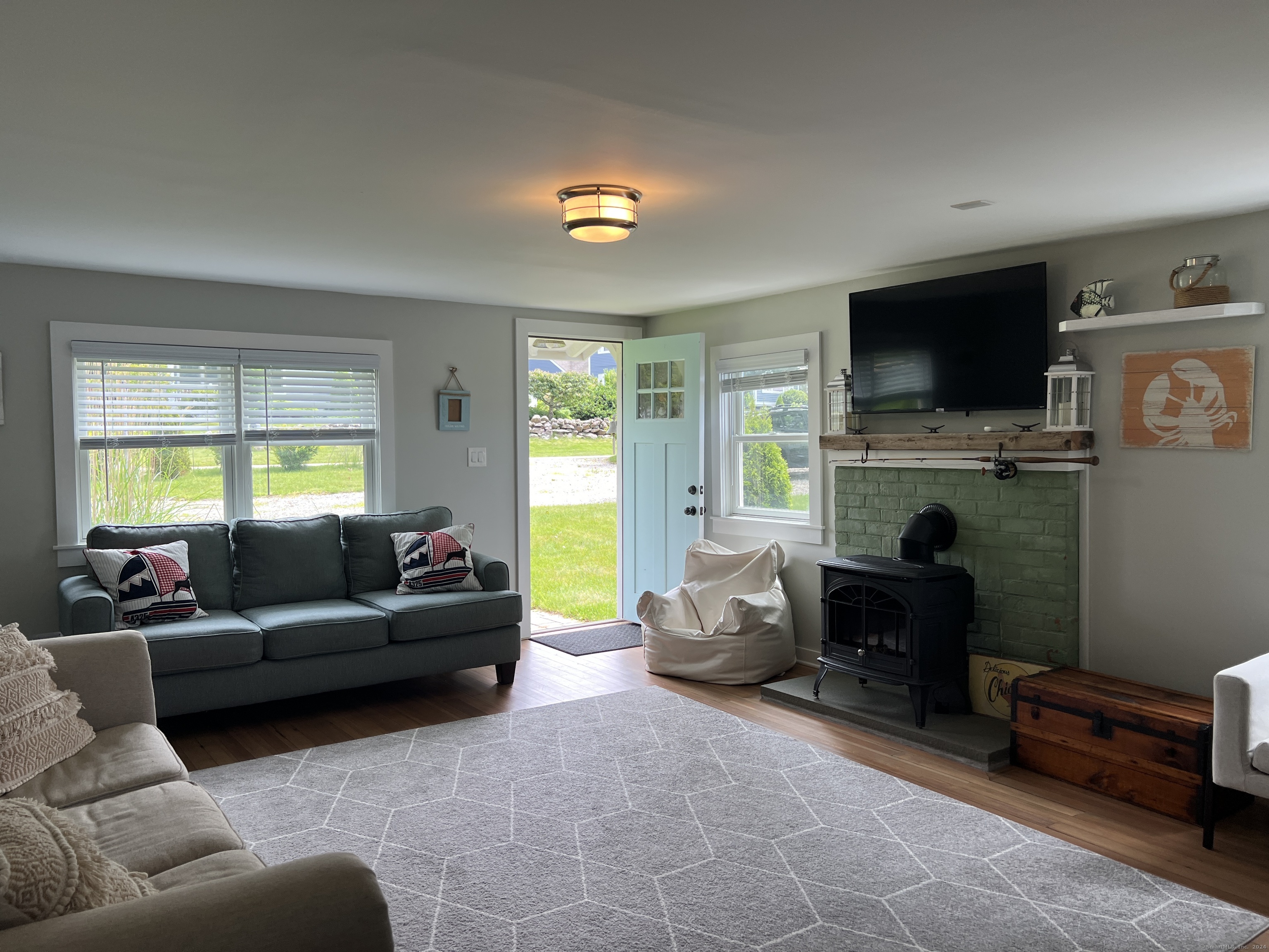 61 Old Black Point Road East Lyme, CT 06357 - Photo 7 of 27 a living room with furniture a flat screen tv and a fireplace