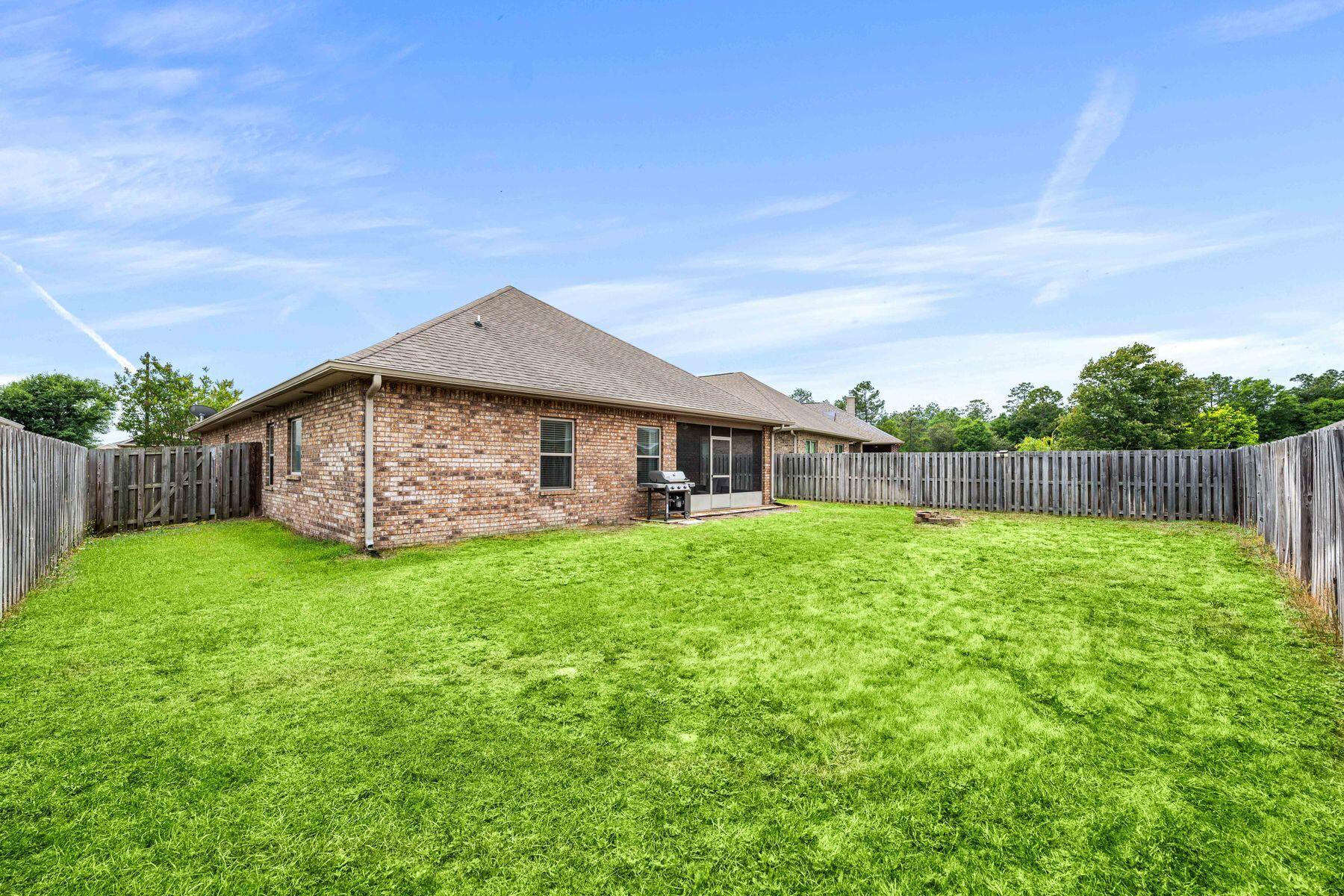 656 Teal Street Crestview, FL 32539 - Photo 11 of 58 a backyard of a house with lots of green space