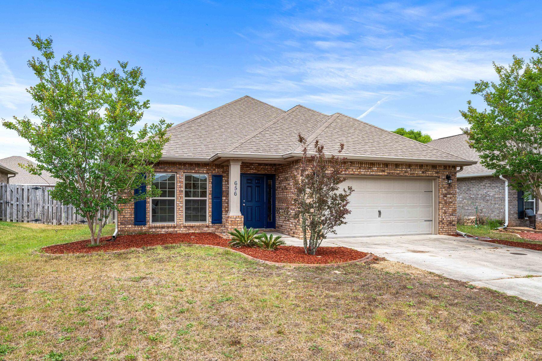 656 Teal Street Crestview, FL 32539 - Photo 2 of 58 a front view of a house with a yard and garage