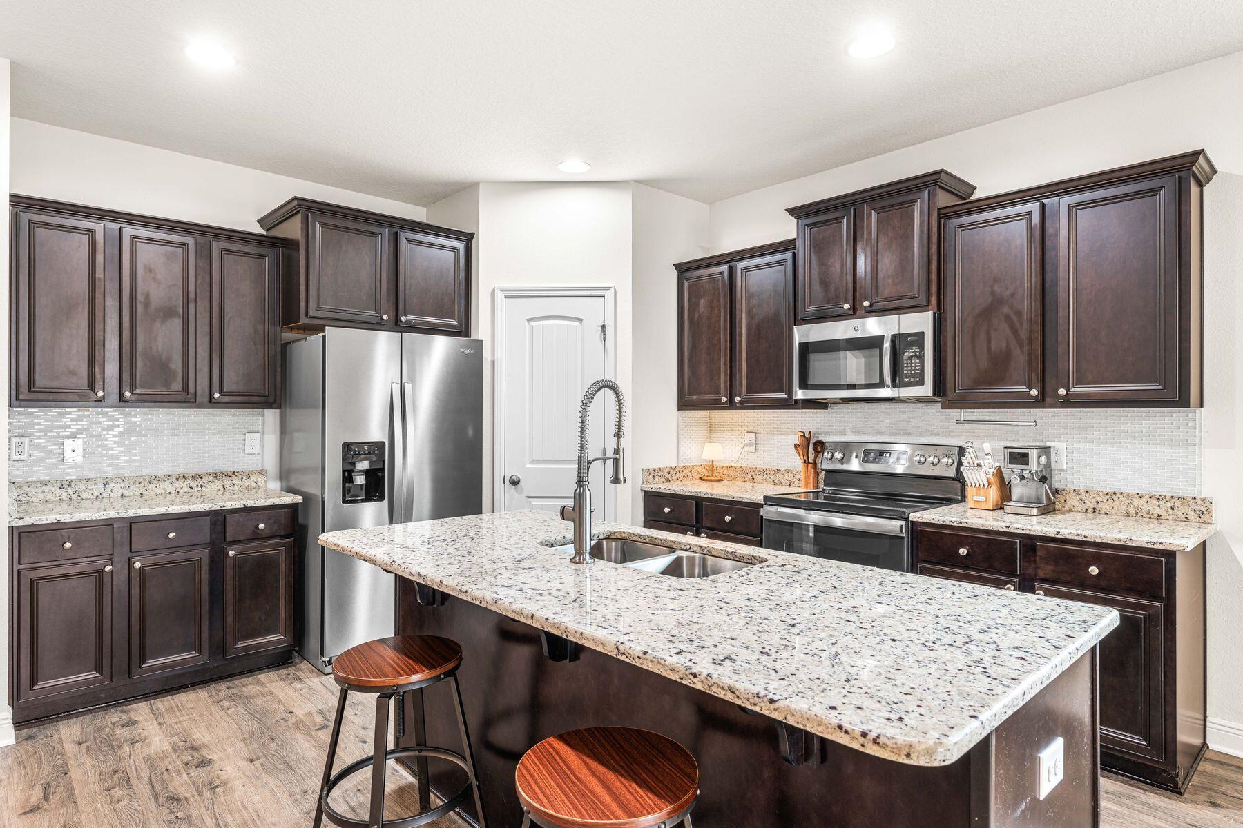 656 Teal Street Crestview, FL 32539 - Photo 24 of 58 a kitchen with granite countertop a sink stove and refrigerator