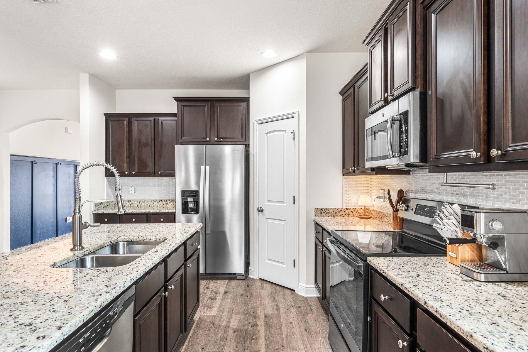 656 Teal Street Crestview, FL 32539 - Photo 25 of 58 a kitchen with granite countertop stainless steel appliances a sink stove refrigerator and cabinets