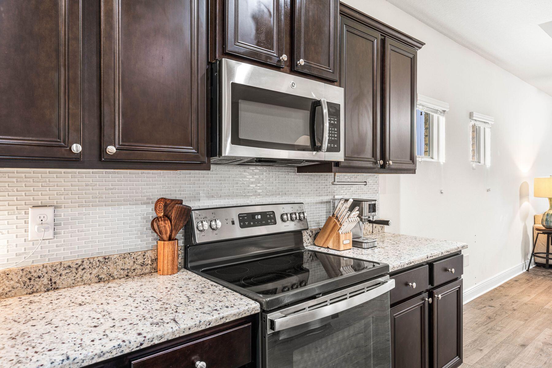 656 Teal Street Crestview, FL 32539 - Photo 26 of 58 a kitchen with granite countertop a sink stove and microwave