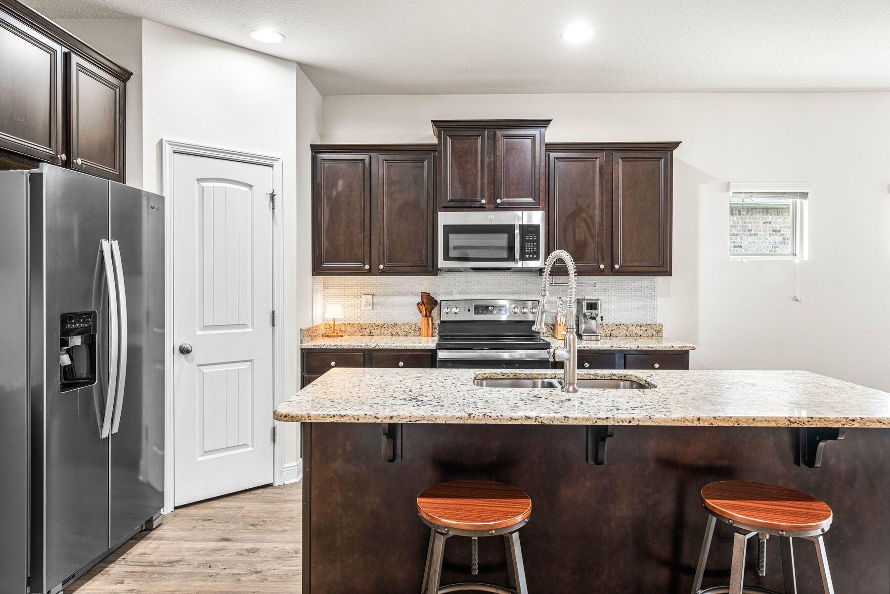 656 Teal Street Crestview, FL 32539 - Photo 27 of 58 a kitchen with stainless steel appliances granite countertop a refrigerator a stove a sink dishwasher and a refrigerator