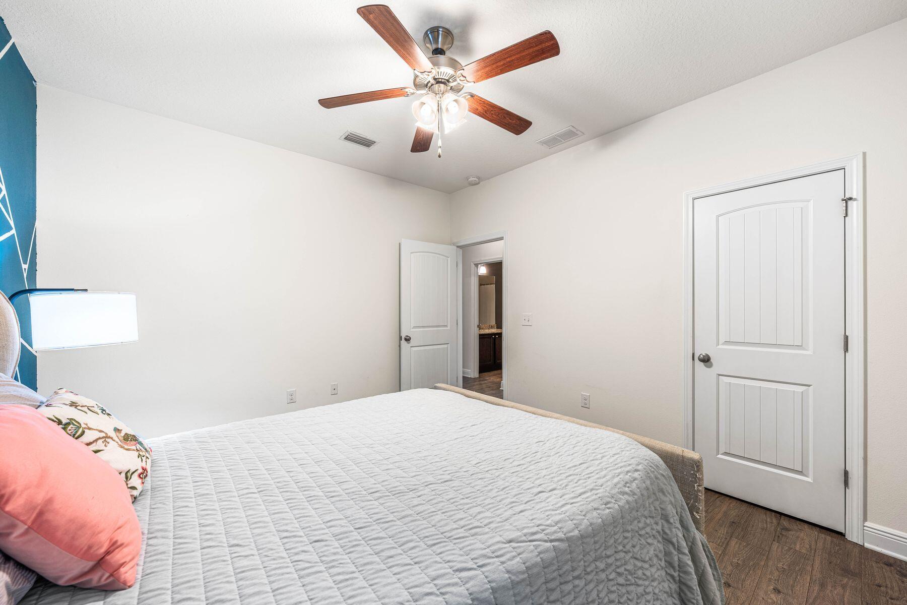 656 Teal Street Crestview, FL 32539 - Photo 33 of 58 a bedroom with a bed and a chandelier