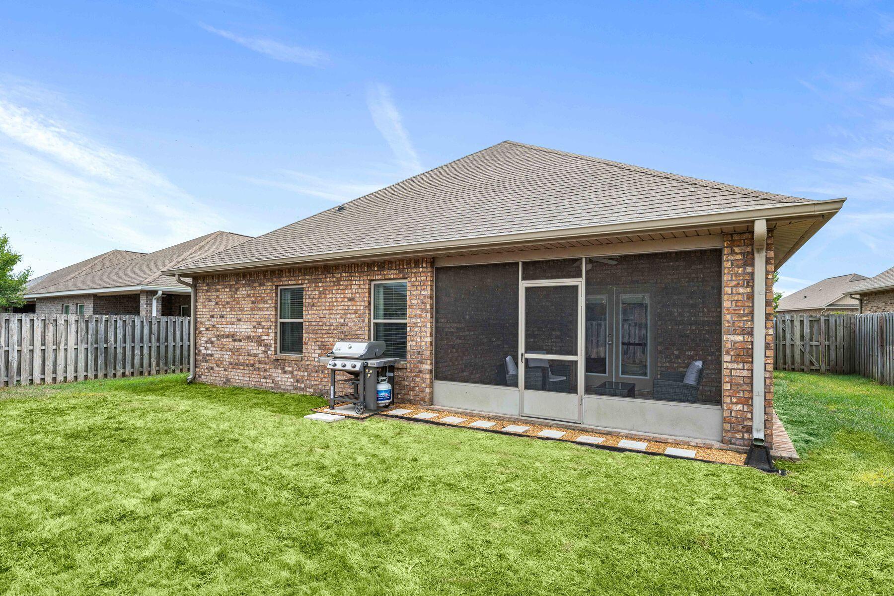656 Teal Street Crestview, FL 32539 - Photo 38 of 58 a view of a house with a yard and sitting area