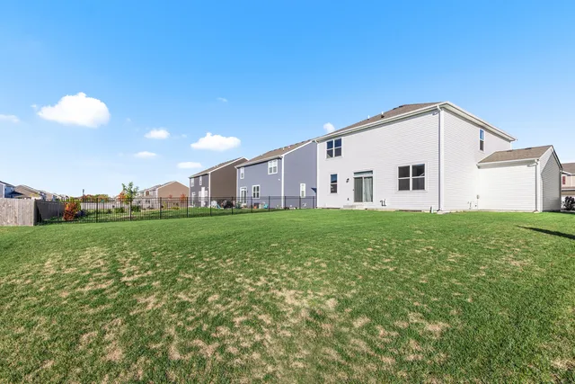 a view of a house with a big yard and a large tree