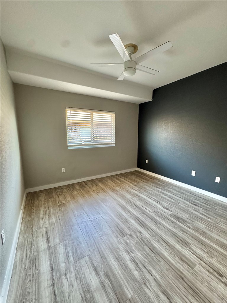 322 Pacific Drive Portland, TX 78374 - Photo 16 of 22 an empty room with wooden floor fan and windows