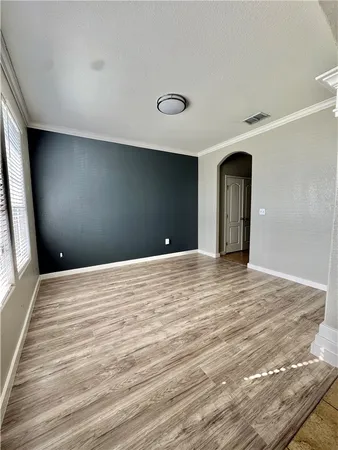 a view of empty room with window and wooden floor