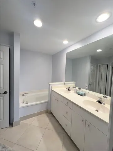 a bathroom with a bathtub a sink and a mirror