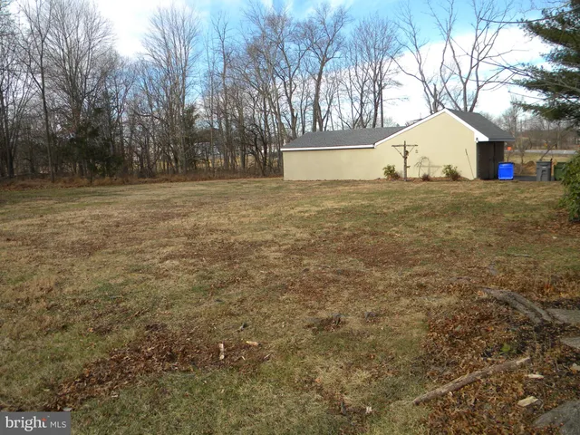 a view of a yard with a house and large trees