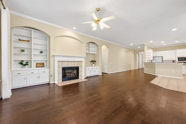 a view of a livingroom with a fireplace a chandelier and wooden floor
