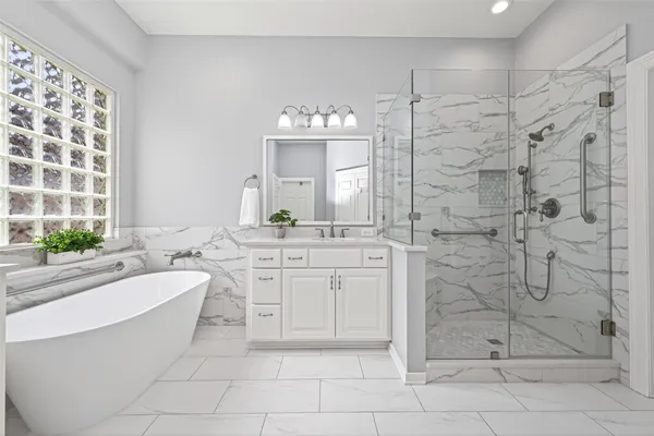 a bathroom with a granite countertop sink a toilet a mirror and shower