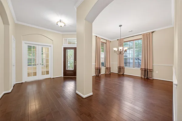 an empty room with wooden floor and a ceiling fan