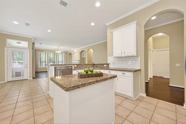 a kitchen with white cabinets and sink