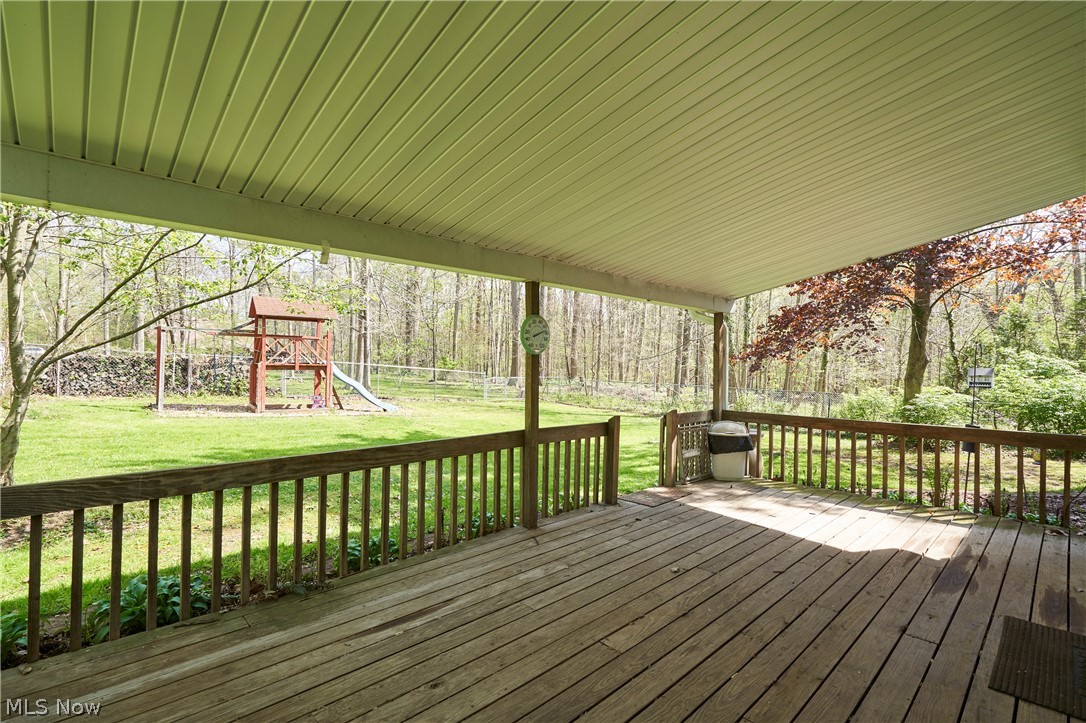3097 Baughman Road Clinton, OH 44216 - Photo 25 of 27 Expansive covered porch featuring a wood deck, wood railing, and a light-colored ceiling