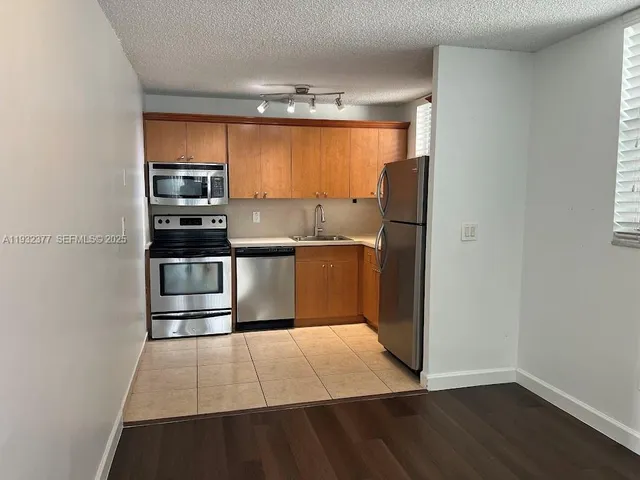 a bathroom with a granite countertop toilet sink and mirror