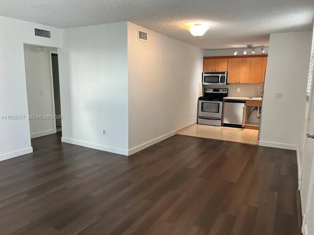 a view of a kitchen with a sink and a refrigerator
