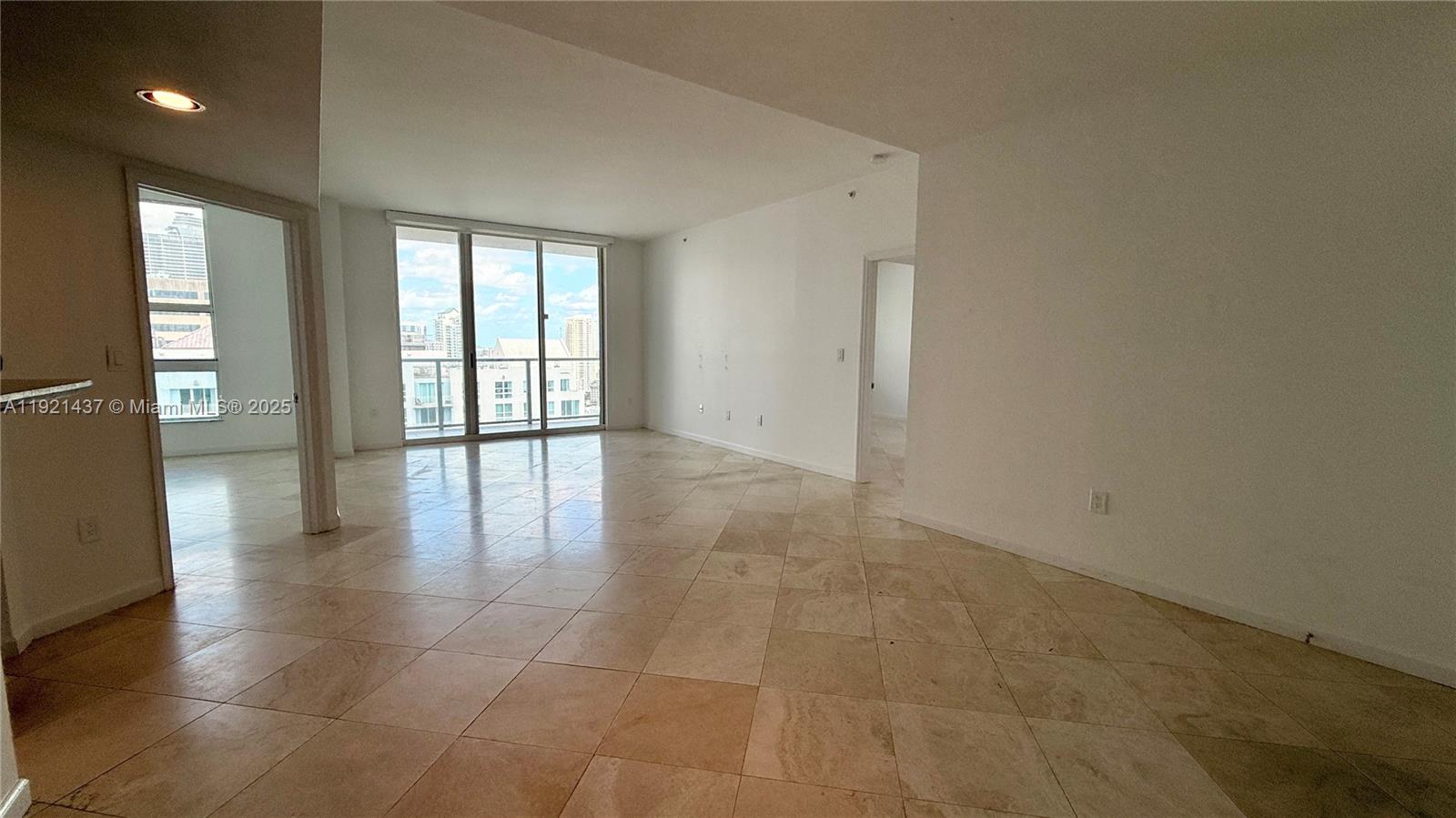 1155 Brickell Bay Drive, Unit PH104 Miami, FL 33131 - Photo 5 of 35 a view of an empty room with glass door and windows