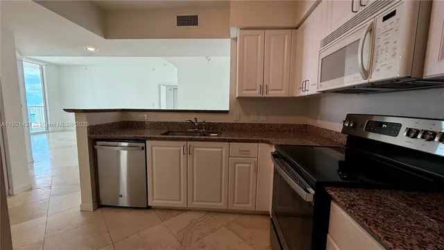 a kitchen with stainless steel appliances granite countertop a stove and a microwave