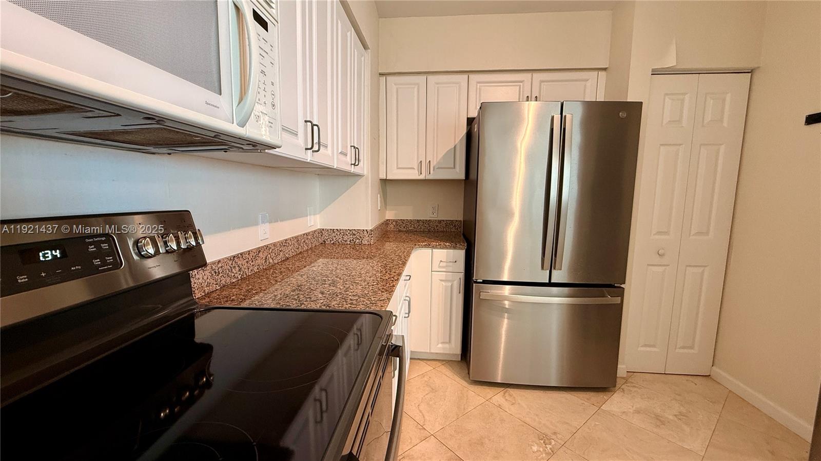 1155 Brickell Bay Drive, Unit PH104 Miami, FL 33131 - Photo 10 of 35 a kitchen with metallic refrigerator and cabinets