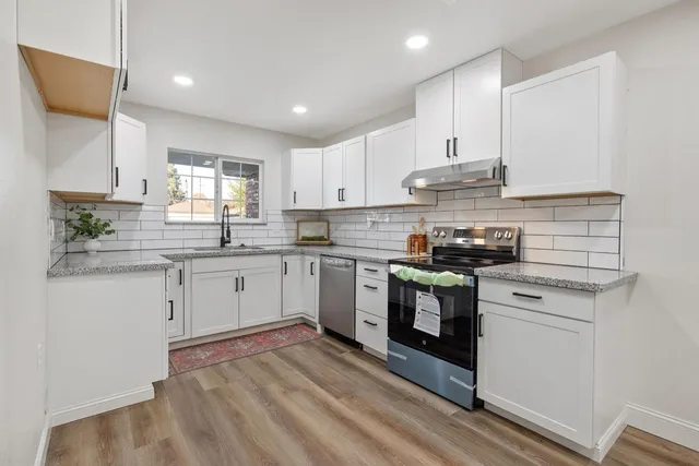 a kitchen with a white cabinets and window