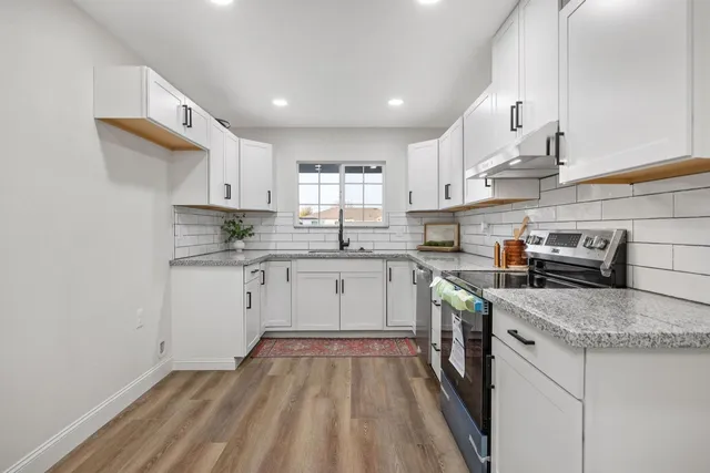 a kitchen with a sink stove and cabinets