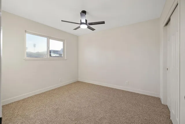a view of empty room with ceiling fan