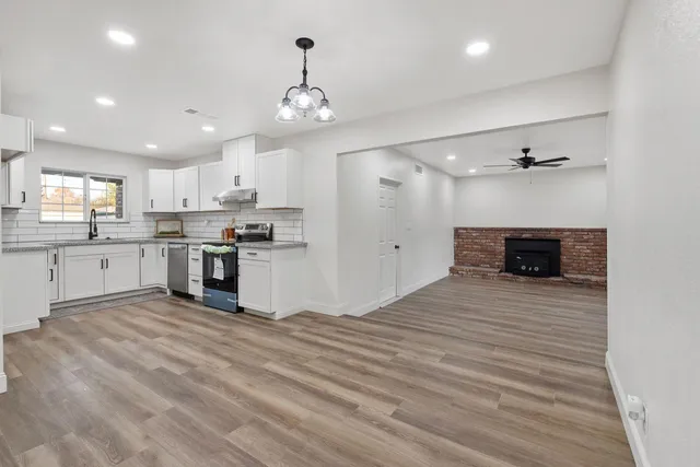 a large kitchen with kitchen island a sink stainless steel appliances and cabinets